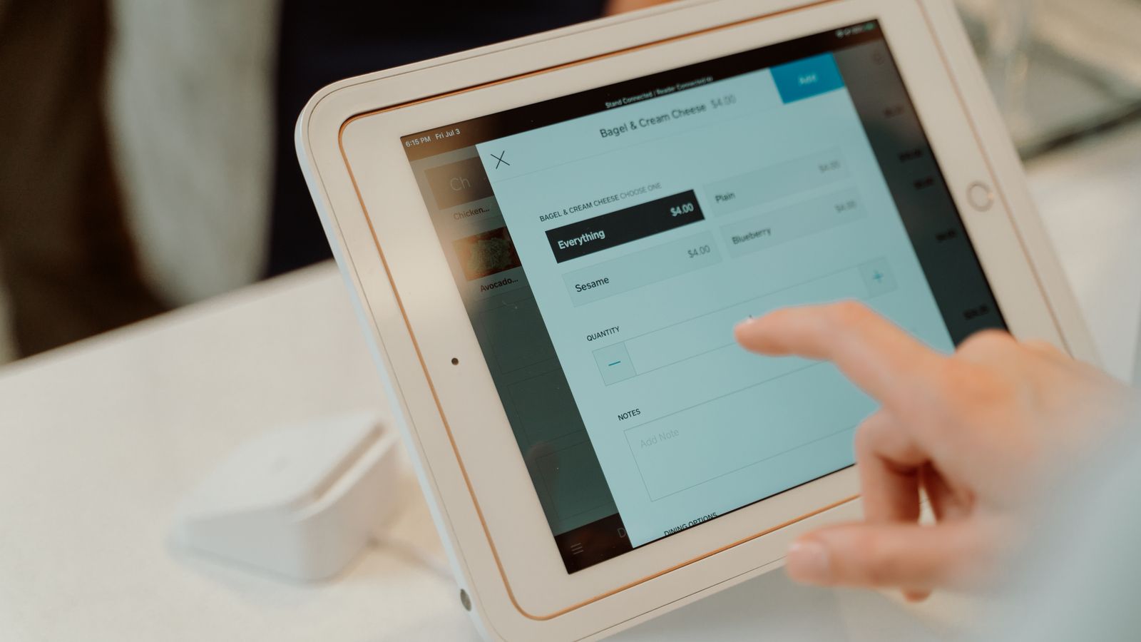 Mano de un cliente eligiendo opciones en la pantalla táctil de una tableta de pedidos